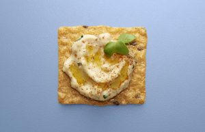 Crunchmaster cracker with hummus on top.