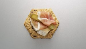 Crunchmaster Multi-Seed cracker topped with proscuitto and brie cheese.