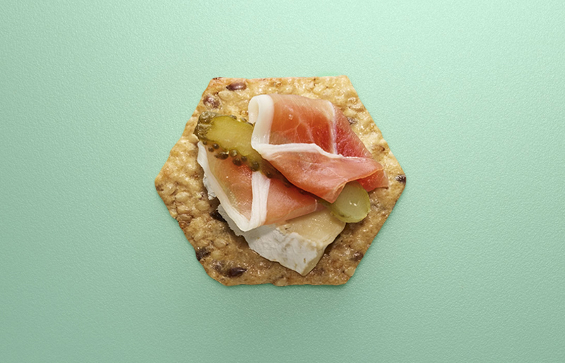 Crunchmaster cracker with prosciutto and brie on top.
