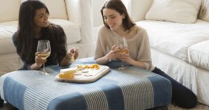 Two friends enjoying Crunchmaster crackers with cheese and wine