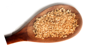 Wooden spoon full of rice, a key ingredient in Crunchmaster crackers.