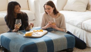Two friends enjoy Crunchmaster crackers, cheese and wine.