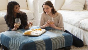 Two girls enjoying Crunchmaster crackers, cheese and wine.